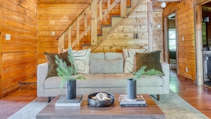 Ein Holzinterieur mit einer Couch, zwei Vasen und einer Schale mit dekorativen Gegenständen.
