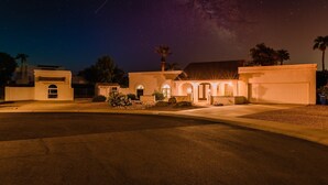 A residential property with a driveway, a garage, and a well-lit entrance. - Desert Ridge by Avantstay Spacious Oasis w/ Pool & Hot Tub (Scottsdale)