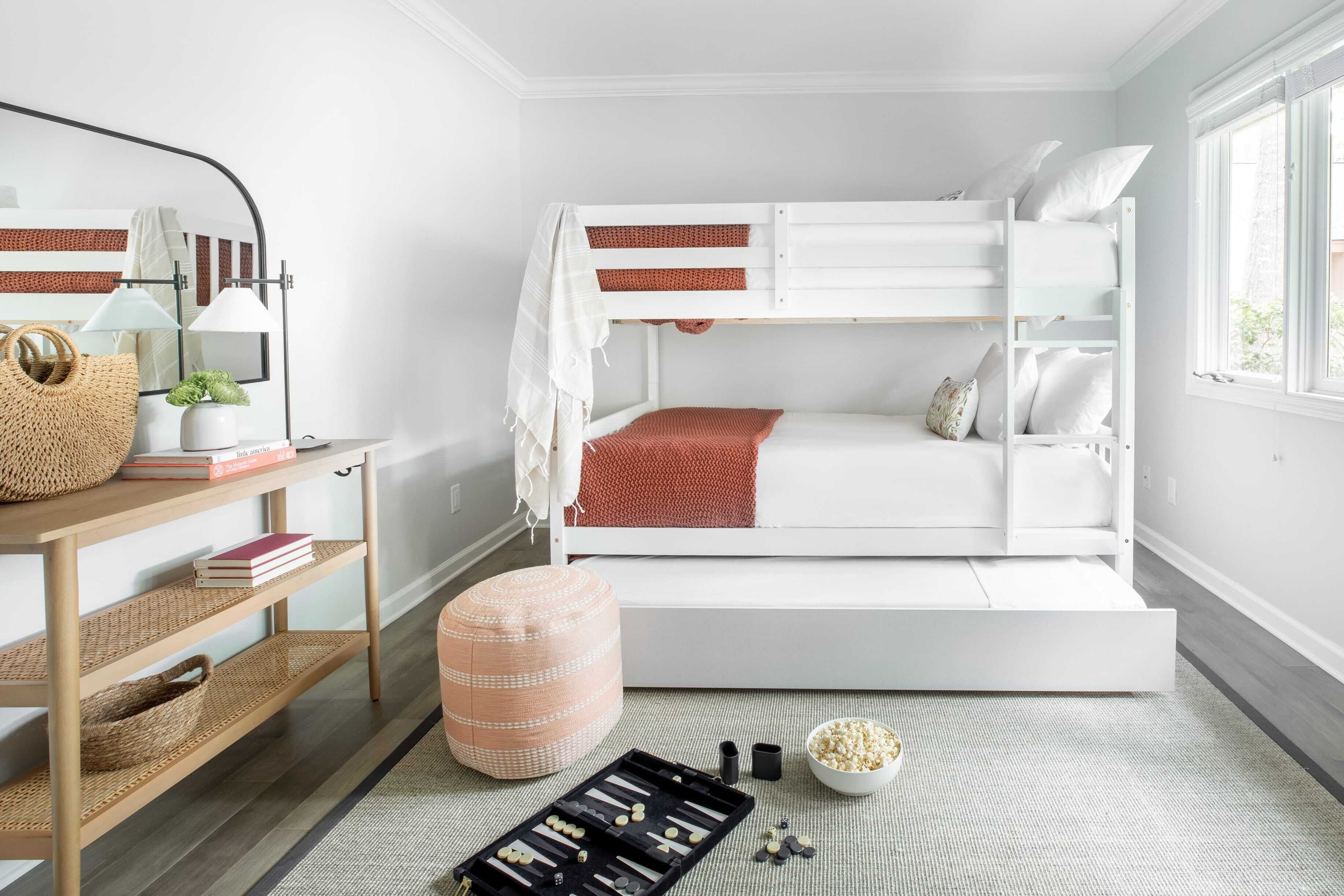 Une chambre avec un lit superposé, un bureau, une lampe et une fenêtre.