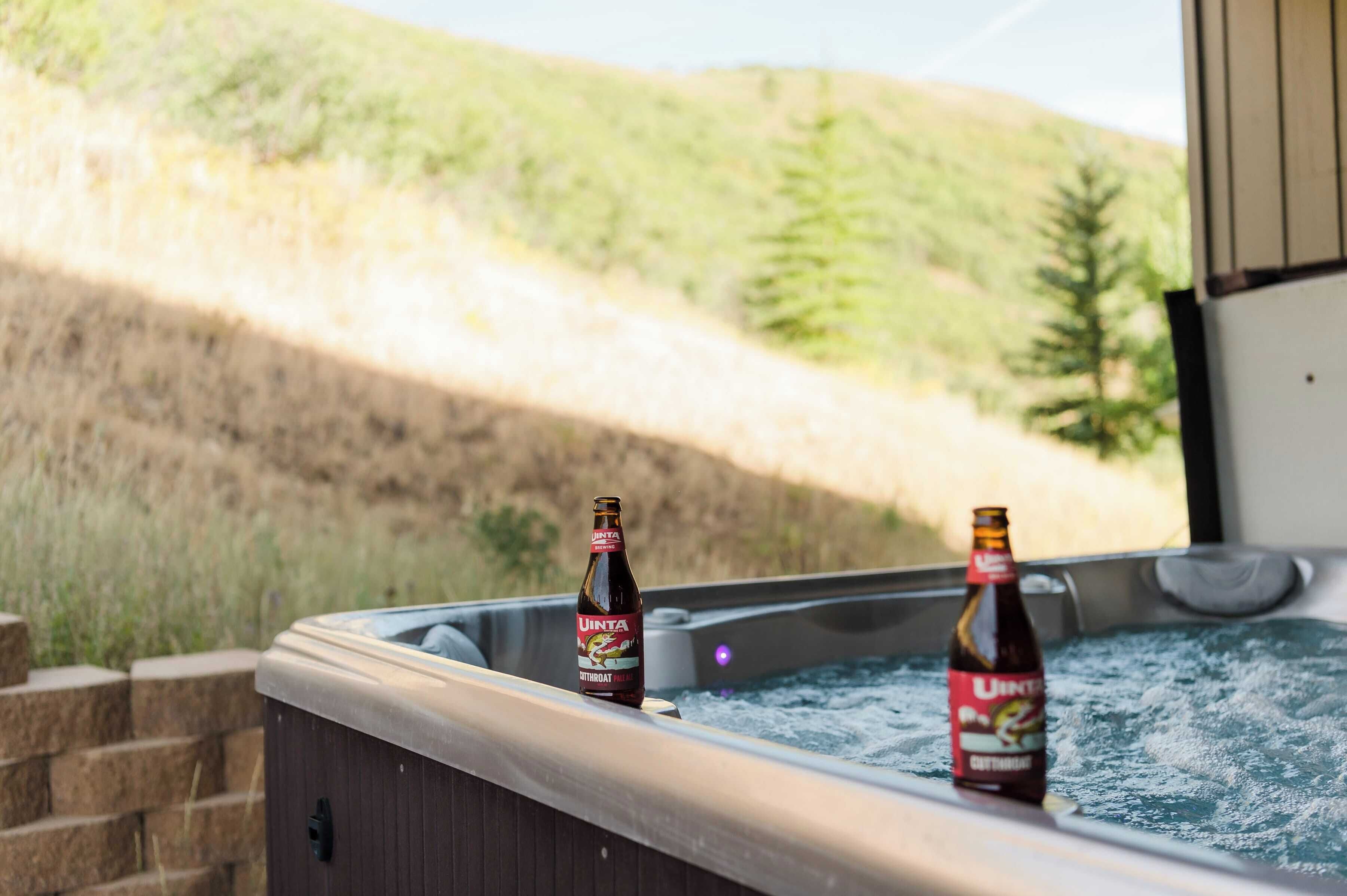 A hot tub with two bottles of Uinta beer.