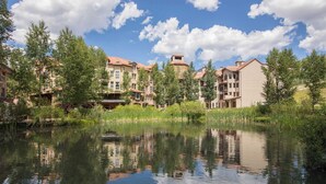 A lakeside hotel with multiple buildings, a clear sky, and a calm lake reflecting the structures. - Westermere 311 - 2 by Avantstay Just Steps From Ski Area w/ Great Views! (Telluride)