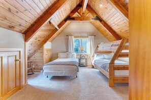 A cozy attic bedroom with wooden beams, two bunk beds, a window with curtains, and a small bedside table. - Ember by Avantstay Majestic Entertainers Home w/ Pine Tree Views & Close to Meek's Bay (Tahoma)