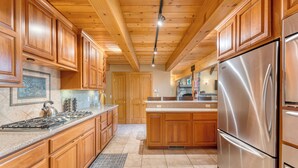 Una cocina amplia con armarios de madera, un refrigerador de acero inoxidable y una encimera de granito.