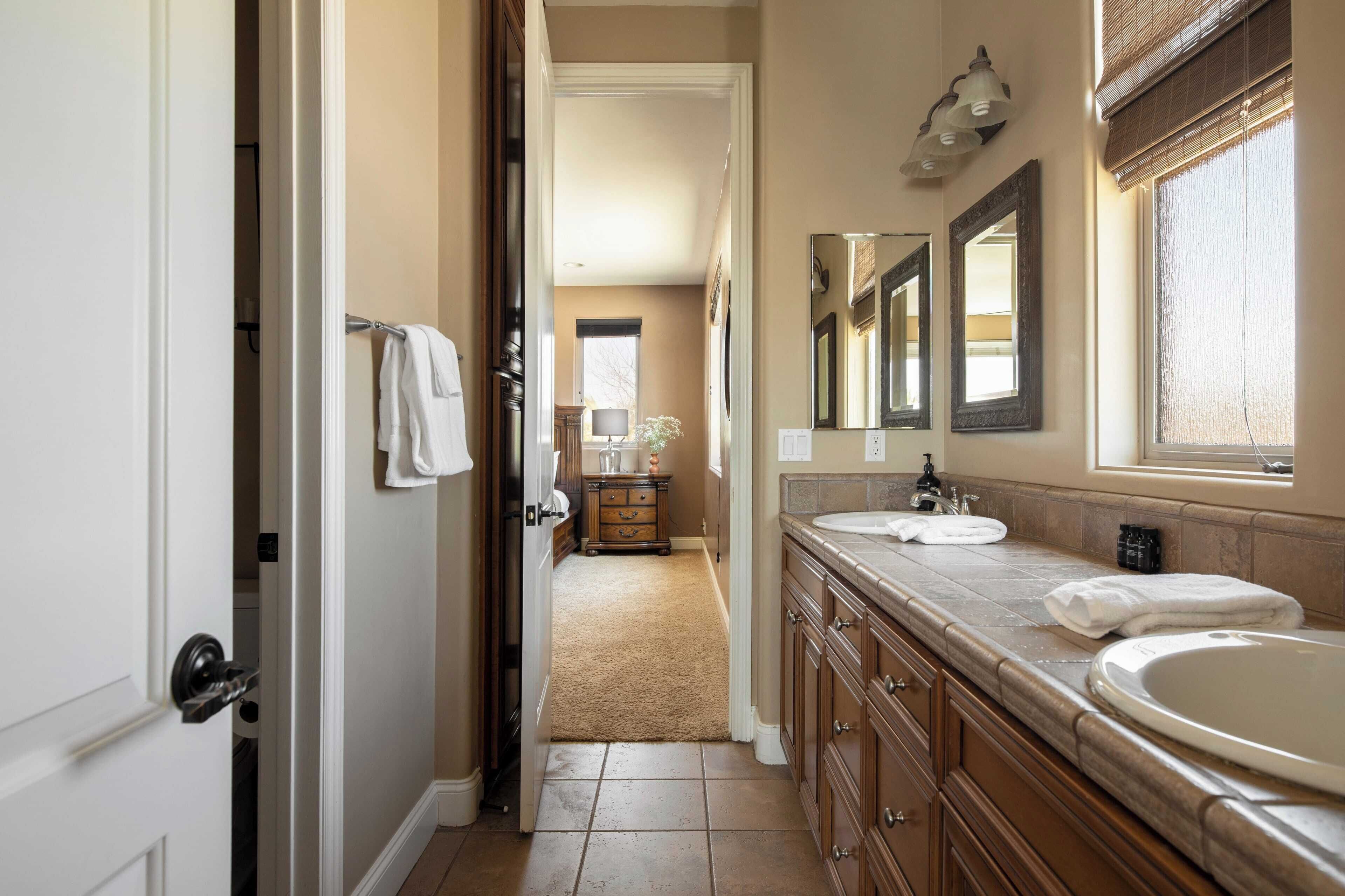 A bathroom with two sinks, a mirror, and a towel rack.