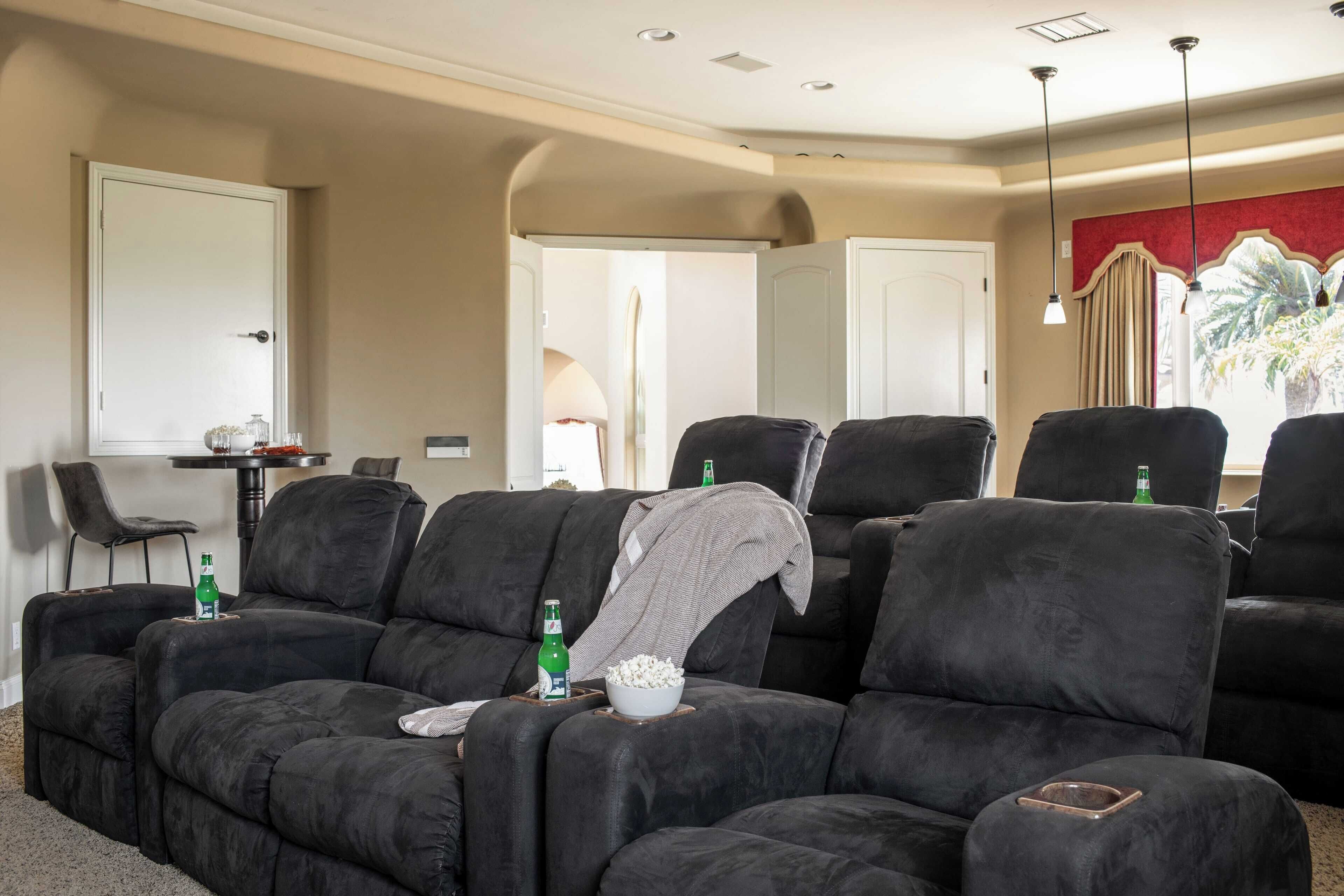 A living room with a sectional sofa, a small table, and a door leading to another room.