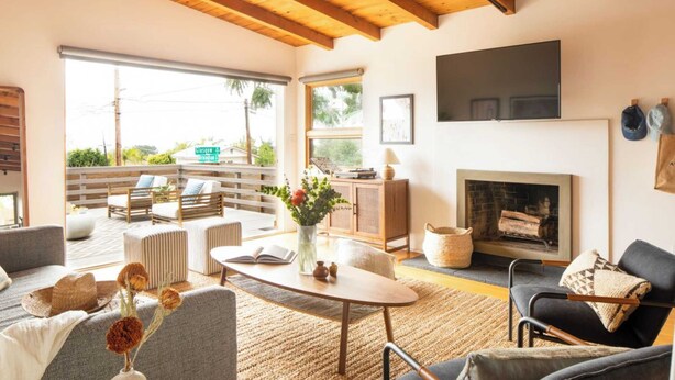 Un salón espacioso con chimenea, asientos cómodos y vistas al exterior.