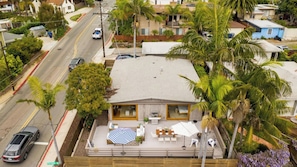 Une maison avec un patio, un coin repas et une piscine.