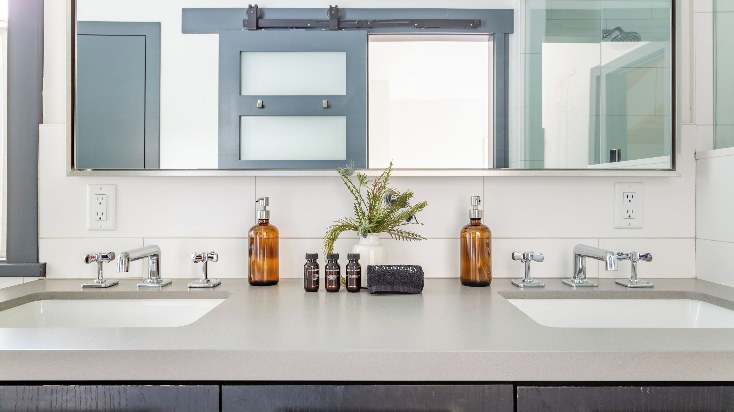 A bathroom with two sinks, a mirror, and a window.