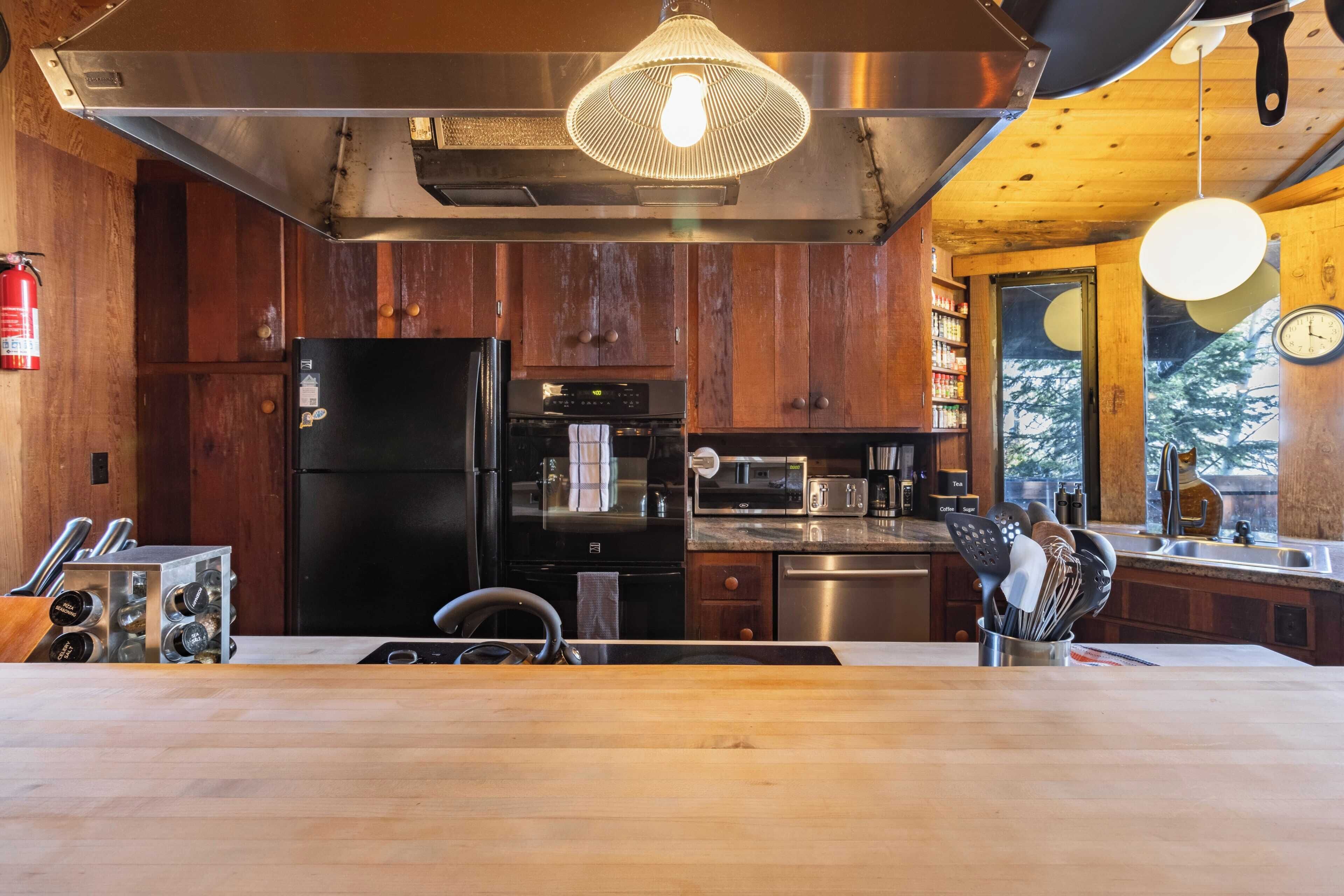 A modern kitchen with wooden cabinets, stainless steel appliances, and a central island.