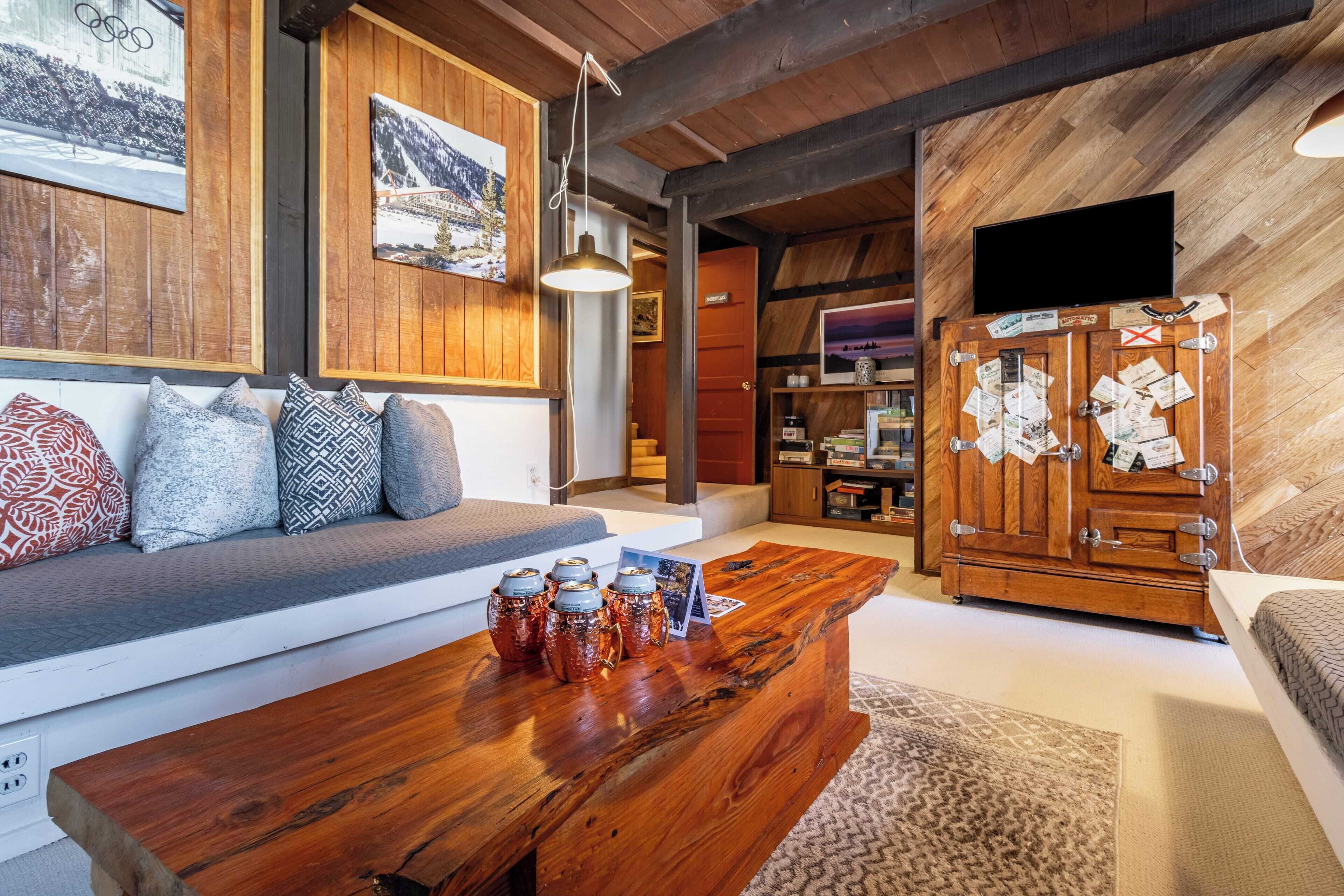 A cozy living area with a wooden bench, a coffee table with jars, and a cabinet with papers.