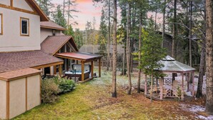 A large house with a covered patio and a gazebo in a wooded area. - River Rock by Avantstay Sleeps 20 w/ Hot Tub + Game Room & Theater 10 Min Walk to Mtn (Breckenridge)
