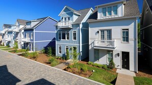A row of townhouses with front porches, a paved driveway, and a well-maintained lawn. - Linda, Emmylou & Patsy by Avantstay 3 Unit Buyout w/ 11br in Heart of Nashville (Nashville)
