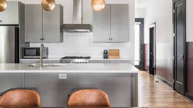 A modern kitchen with a central island, stainless steel appliances, and pendant lighting. - Linda, Emmylou & Patsy by Avantstay 3 Unit Buyout w/ 11br in Heart of Nashville (Nashville)
