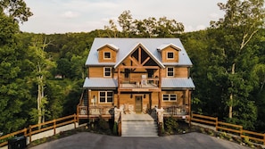 A two-story lodge with a balcony, a front porch, and a staircase leading to the entrance.