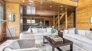 Ein geräumiger Wohnbereich mit einer großen Couch, einem Couchtisch und einer Treppe zu einer oberen Ebene.
