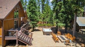 Une cabane en bois dotée d’une terrasse, d’un bain à remous et de meubles de jardin.