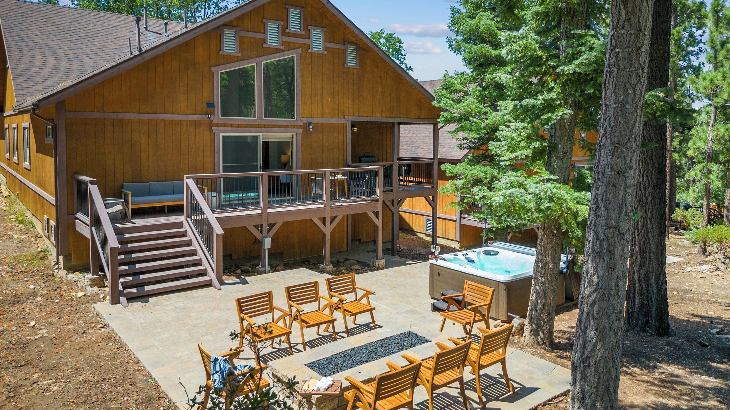 Une cabane en bois dotée d’une terrasse, d’un espace salon extérieur et d’un bain à remous.