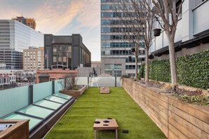 A rooftop terrace with a green lawn, a wooden table, and a telescope. - Paramount Place by Avantstay 4 Story Apartment in Heart of Austin w/ Movie Theatre (Austin)