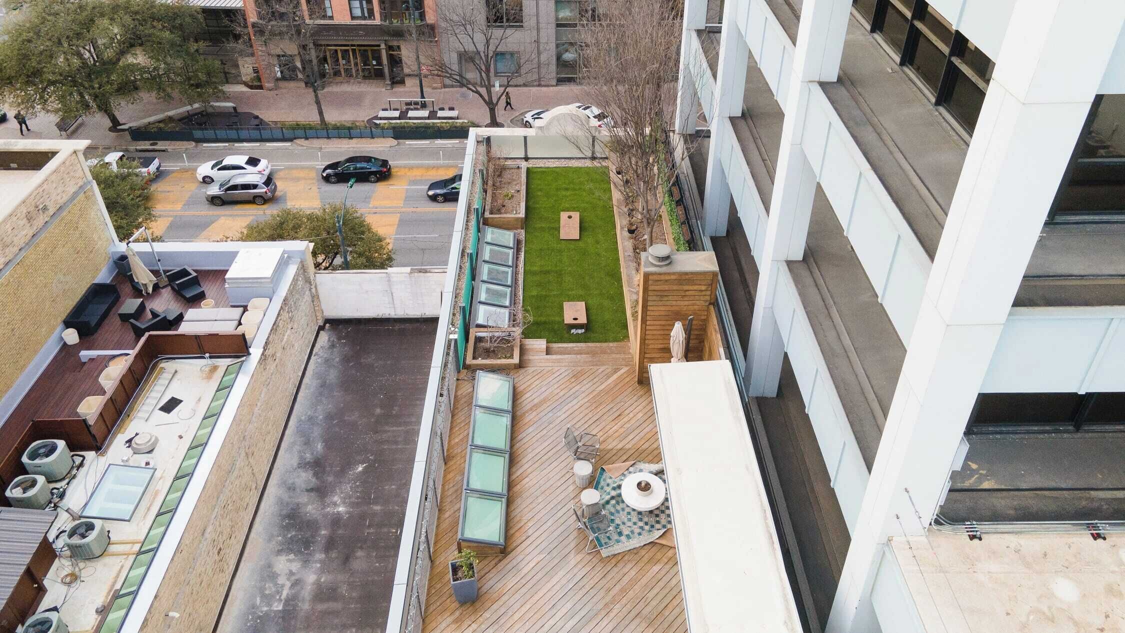 Terraço no telhado com deck de madeira, área de estar externa e pequeno jardim.