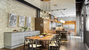 A modern kitchen with a central island, grey cabinetry, and a hanging light fixture.