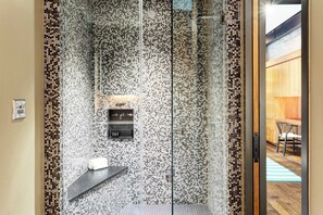 A modern bathroom with a mosaic wall, a glass shower enclosure, and a wooden door leading to a dining area. - Paramount Place by Avantstay 4 Story Apartment in Heart of Austin w/ Movie Theatre (Austin)