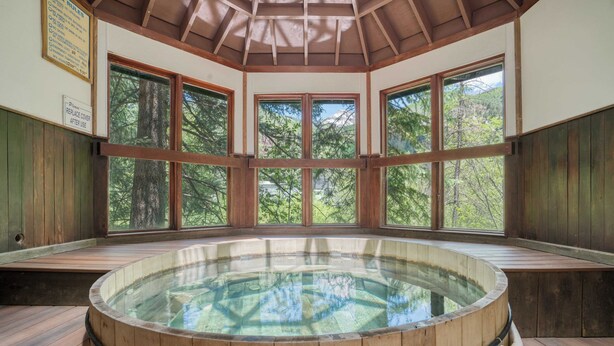 A wooden hot tub with a glass enclosure, surrounded by wooden walls and large windows offering a view of trees. - Manitou Riverhouse 115 by Avantstay Spacious Condo in the Centre of Telluride (Telluride)