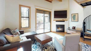 A modern living room with a fireplace, a sofa, a coffee table, and a staircase. - Sockeye by Avantstay Modern 2 BR Condo w/ Access to Northstar Resort Community (Truckee)