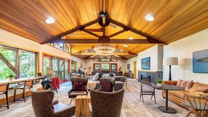 A spacious lobby with wooden ceiling beams, comfortable seating, large windows, and a chandelier. - Sockeye by Avantstay Modern 2 BR Condo w/ Access to Northstar Resort Community (Truckee)