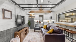 Una cocina moderna con armarios blancos, encimera de madera y un amplio ventanal.