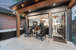 Een moderne buitenruimte met een 'WELCOME' bord, een jacuzzi en een terras met zitplaatsen.