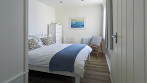 Une chambre à coucher avec un lit, une commode et une chaise.