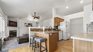 A modern kitchen with a central island, wooden cabinets, and a built-in dishwasher. - *Backyard*King*Parking*100Mbps*Smart TV*Bbq*W/D (Boise)