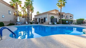 A swimming pool with lounge chairs and palm trees, surrounded by a building with balconies. - Cozy Desert Getaway*Inviting Pool*Smart TV*Gym (Fountain Hills)