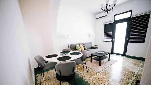 Un espace repas comprenant une table ronde, des chaises, un canapé et une table basse.