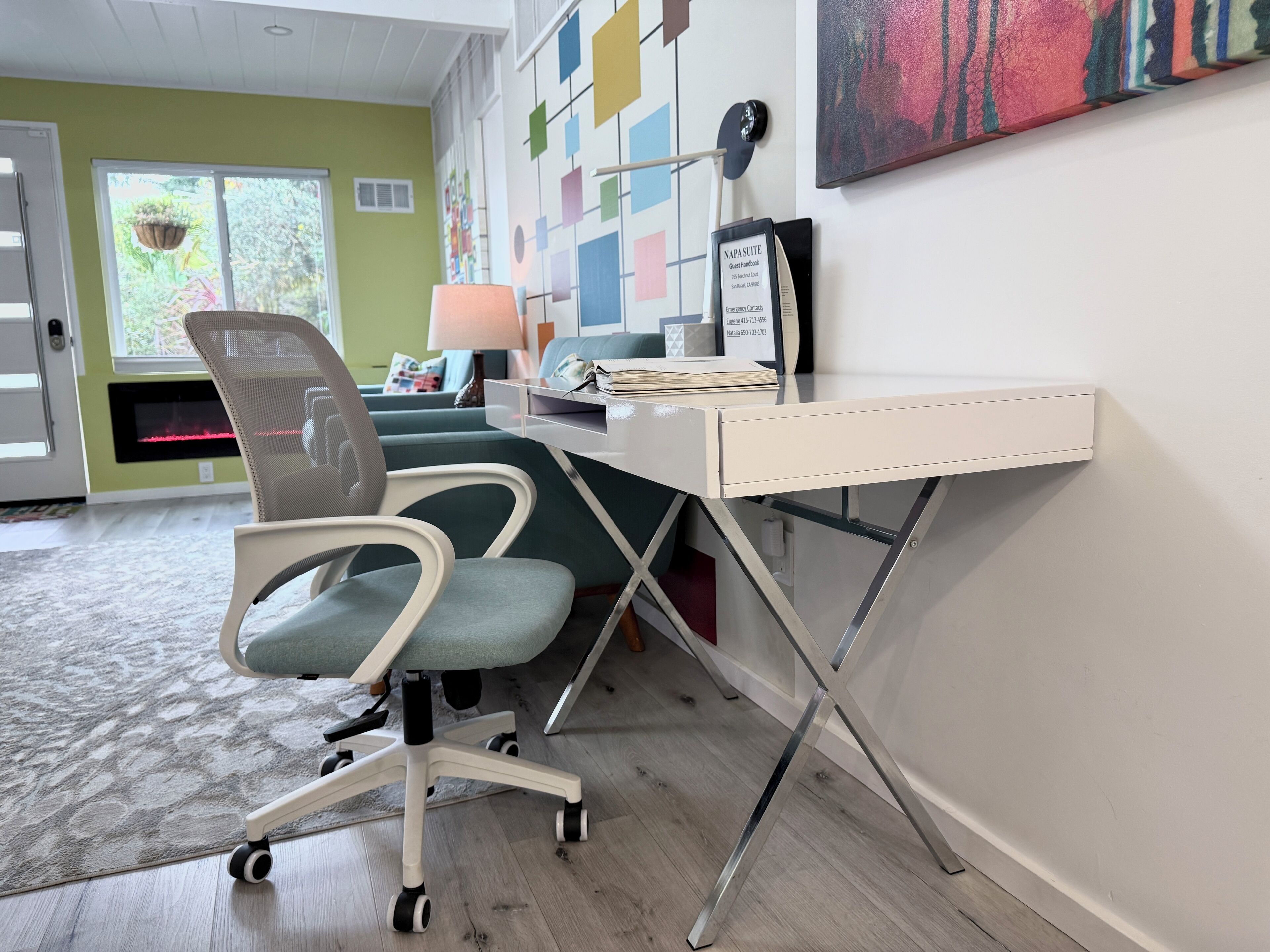 Ein moderner Arbeitsplatz mit Schreibtisch, ergonomischem Stuhl und einem an der Wand befestigten Computer.