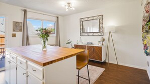 A modern kitchen with a wooden countertop, white cabinetry, and a vase of flowers. - Cozy and modern townhome in Aurora, 5min from highway ! (Aurora)