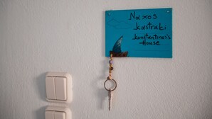 A blue sign with text and a keychain. - Cycladic Seaside House “Konstantinos” by Kastraki Family House (Kastraki Naxos)