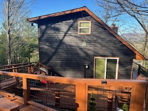 A cabin with a wooden deck, a small window, and a door.