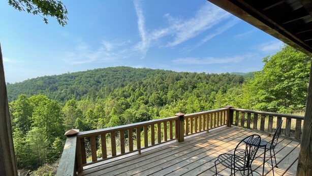 A wooden deck with a railing overlooking a forested hillside. - Big Rock Ridge - Easy Access for mountain views! (Murphy)