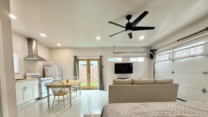A compact bedroom with a bed, a ceiling fan, a TV, and a kitchenette. - Renovated studio 15 minutes from downtown San Diego (Lemon Grove)