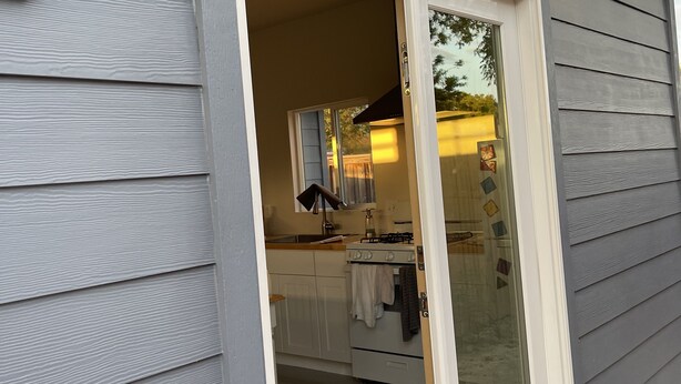 A modern kitchen with a white stove, a sink, and cabinets. - Renovated studio 15 minutes from downtown San Diego (Lemon Grove)