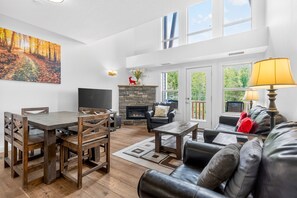A living room with a fireplace, a dining area, and a sofa.