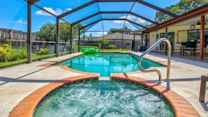 Una piscina exterior cubierta con jacuzzi, rodeada por una terraza de madera y una estructura de techo metálico.