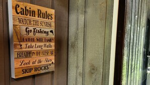 A wooden cabin with a sign listing cabin rules.