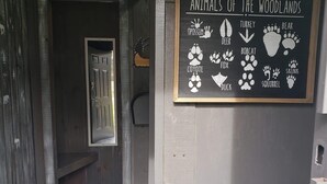 A hallway with a wooden door and a chalkboard sign listing animals of the woodlands.