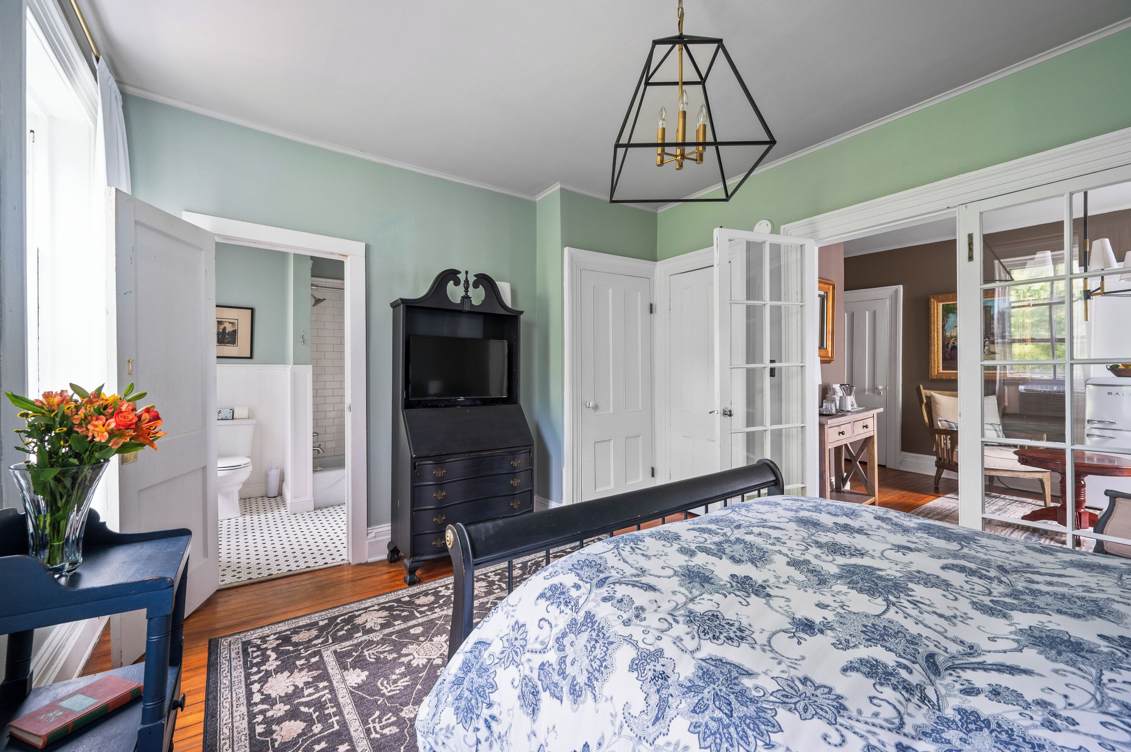 Un dormitorio con cama, cómoda y televisor.