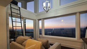 A high-ceiling room with large windows, a ladder, and a chandelier. - The Hangar at On The Rocks Container Scenic Lookout Mountain (Dade County)