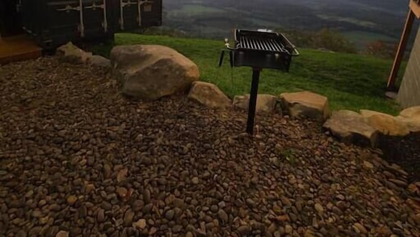 An outdoor patio with a grill, string lights, and a view of the landscape. - The Hangar at On The Rocks Container Scenic Lookout Mountain (Dade County)