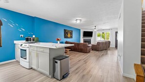 A modern kitchen with white cabinets, a built-in microwave, and a small fridge.