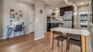 A modern kitchen with a central island, dark cabinets, and stainless steel appliances.